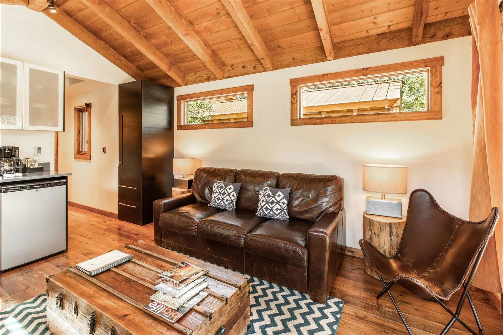 Living room of a Fireside Resort cabin in Jackson Hole with a leather sofa and wood-beamed ceiling